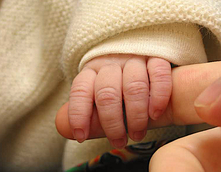 Babyhand umgreift Finger